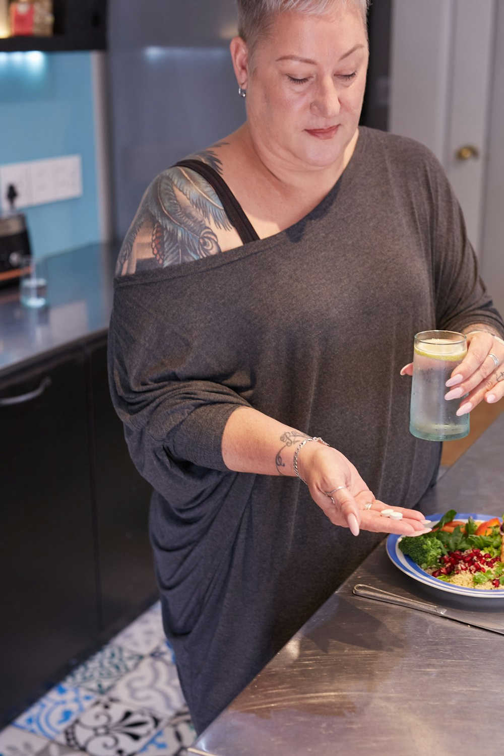 a woman holding a glass of water and a plate of food