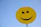 a yellow smiley face sign with a blue sky in the background