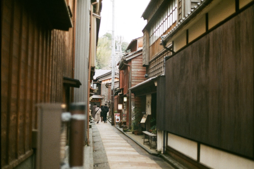 a narrow street with people walking down it