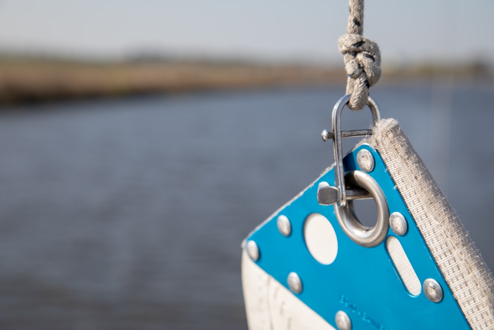 a blue and white boat hanging from a rope