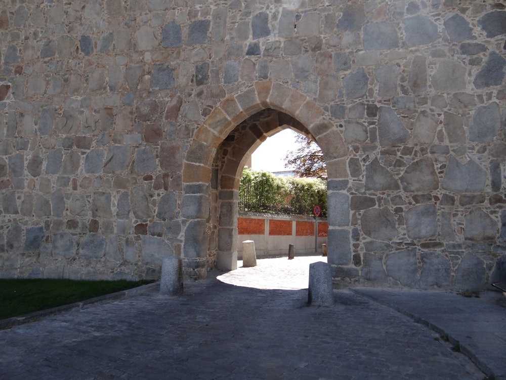 a stone wall with an arched doorway in the middle