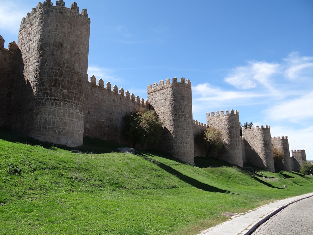 a very tall castle sitting on top of a lush green hillside