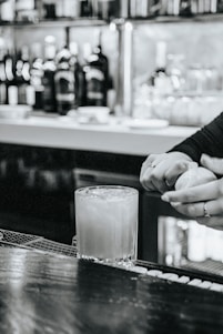 A vibrant cocktail being prepared with fresh ingredients in a stylish bar setting.