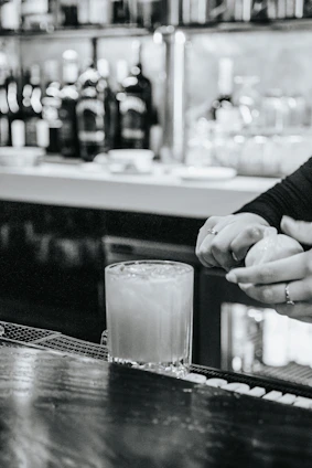 David Córdoba thoughtfully crafting a cocktail in a stylish bar setting.