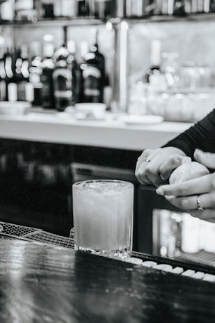 Close-up of a bartender preparing a vibrant cocktail with fresh ingredients.