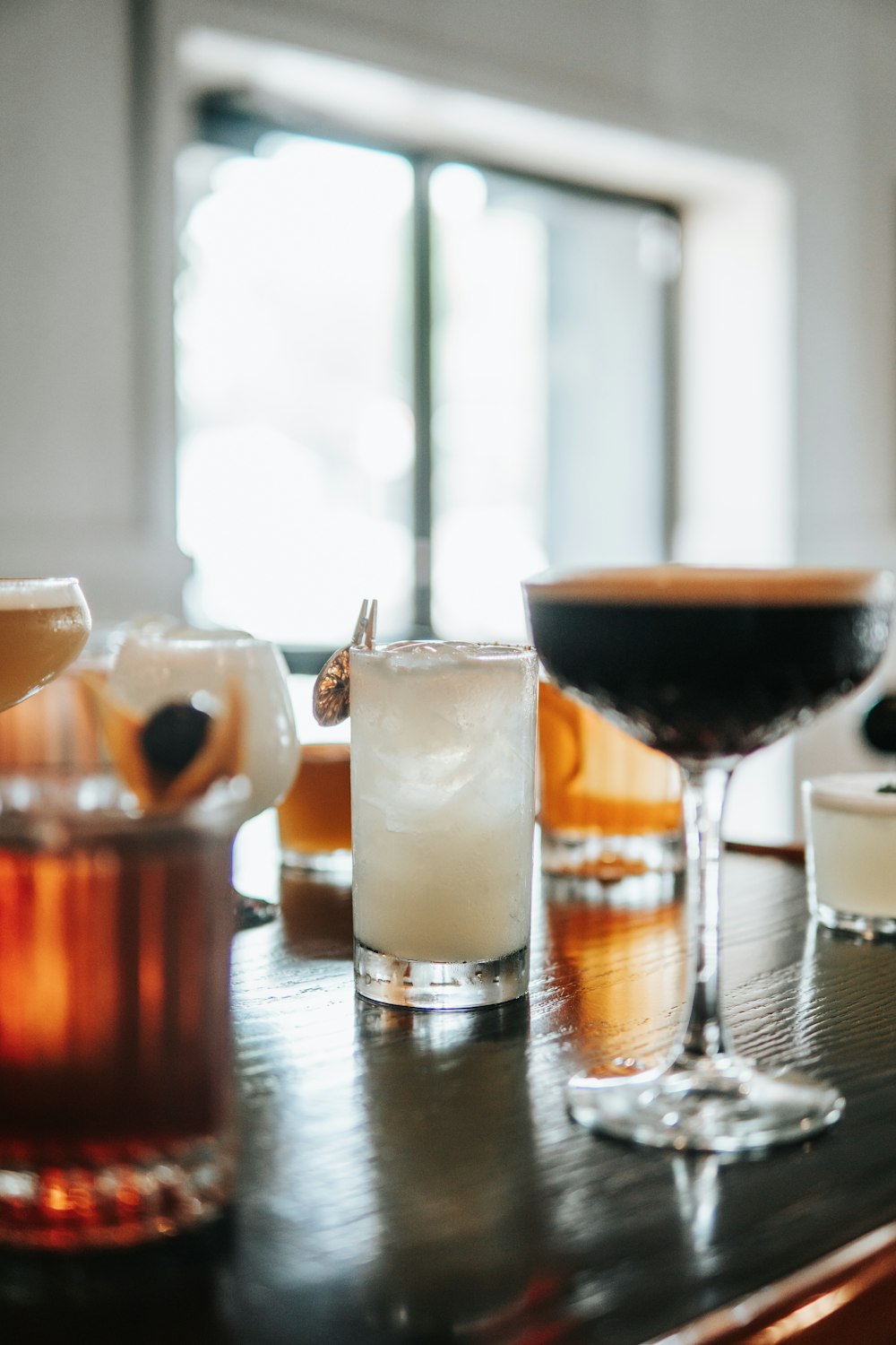 a wooden table topped with glasses filled with drinks