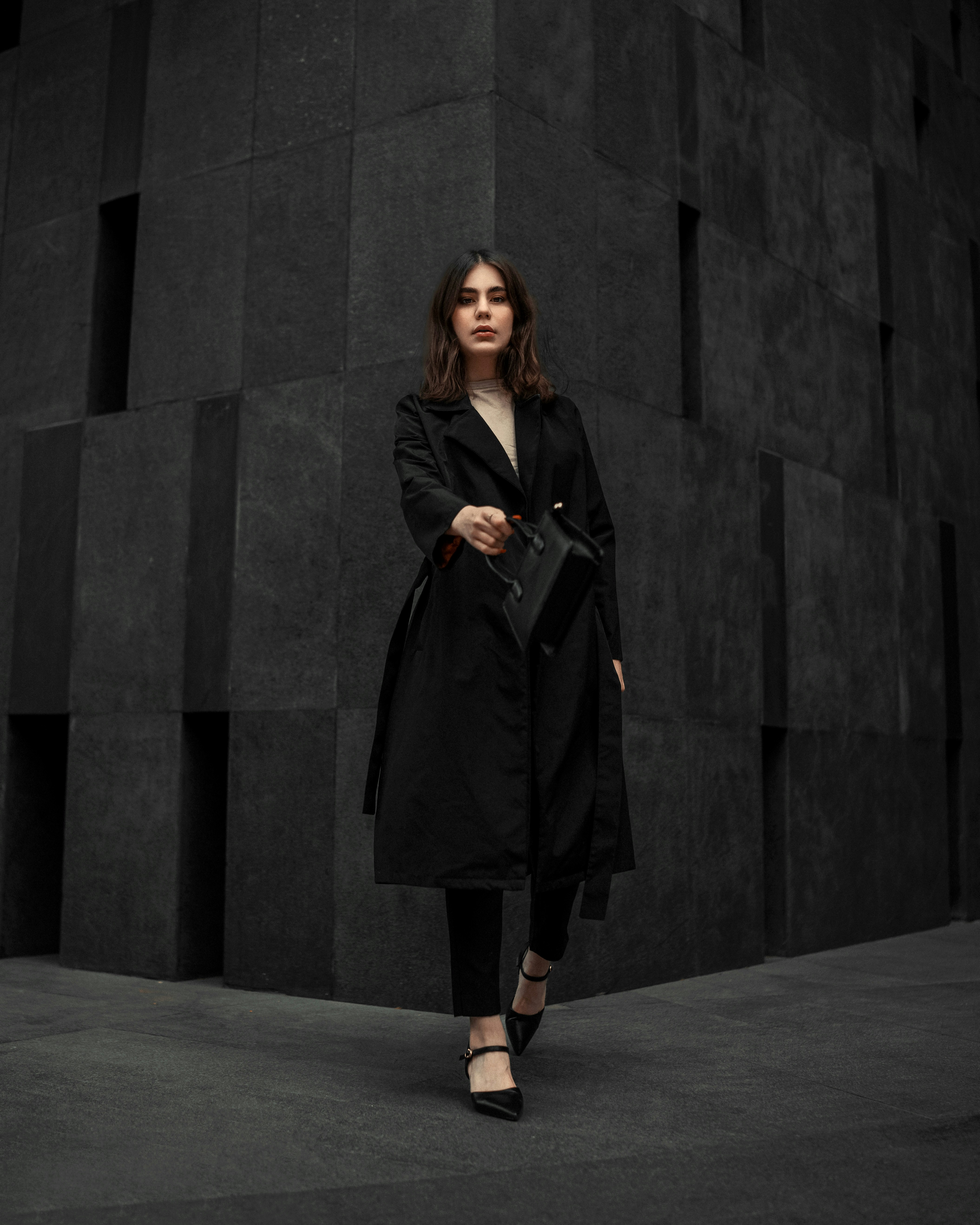 eine frau, die vor einer schwarzen wand steht