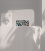 An abstract decorative object made of matte ceramic featuring bold geometric shapes displayed against a neutral wall.