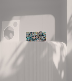 An abstract decorative object made of matte ceramic featuring bold geometric shapes displayed against a neutral wall.