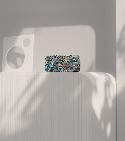 Colorful 3D-printed flexible decorative object bending gracefully on a clean white surface