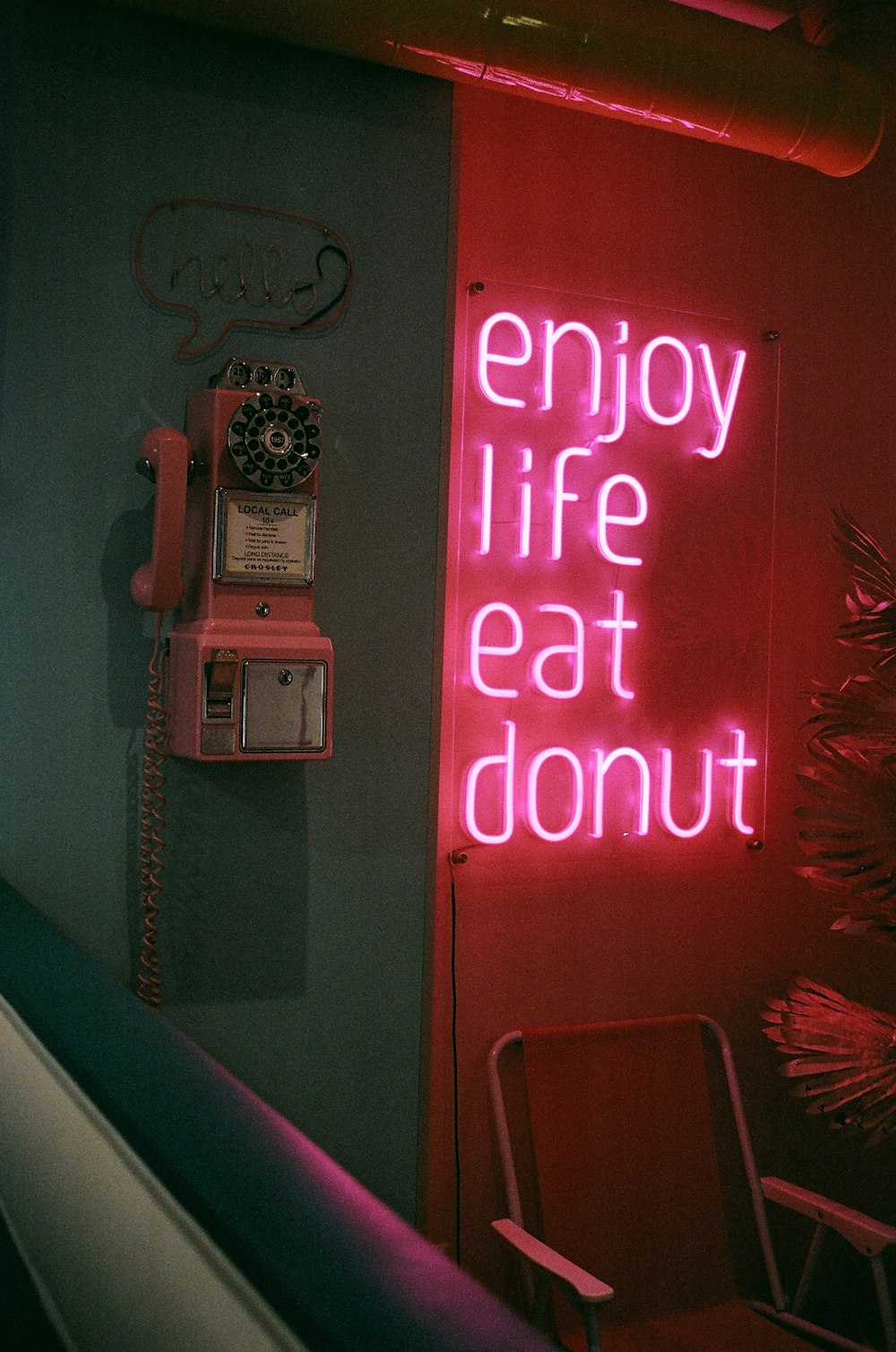 Un letrero de neón que dice Enjoy Life Eat Donut