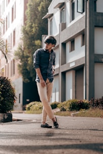 A stylish young man wearing classic cargo pants in an urban setting with warm sunlight.