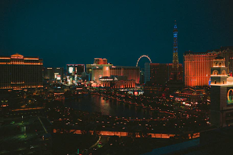 A vibrant cityscape showcasing famous landmarks lit up at night, symbolizing global travel.