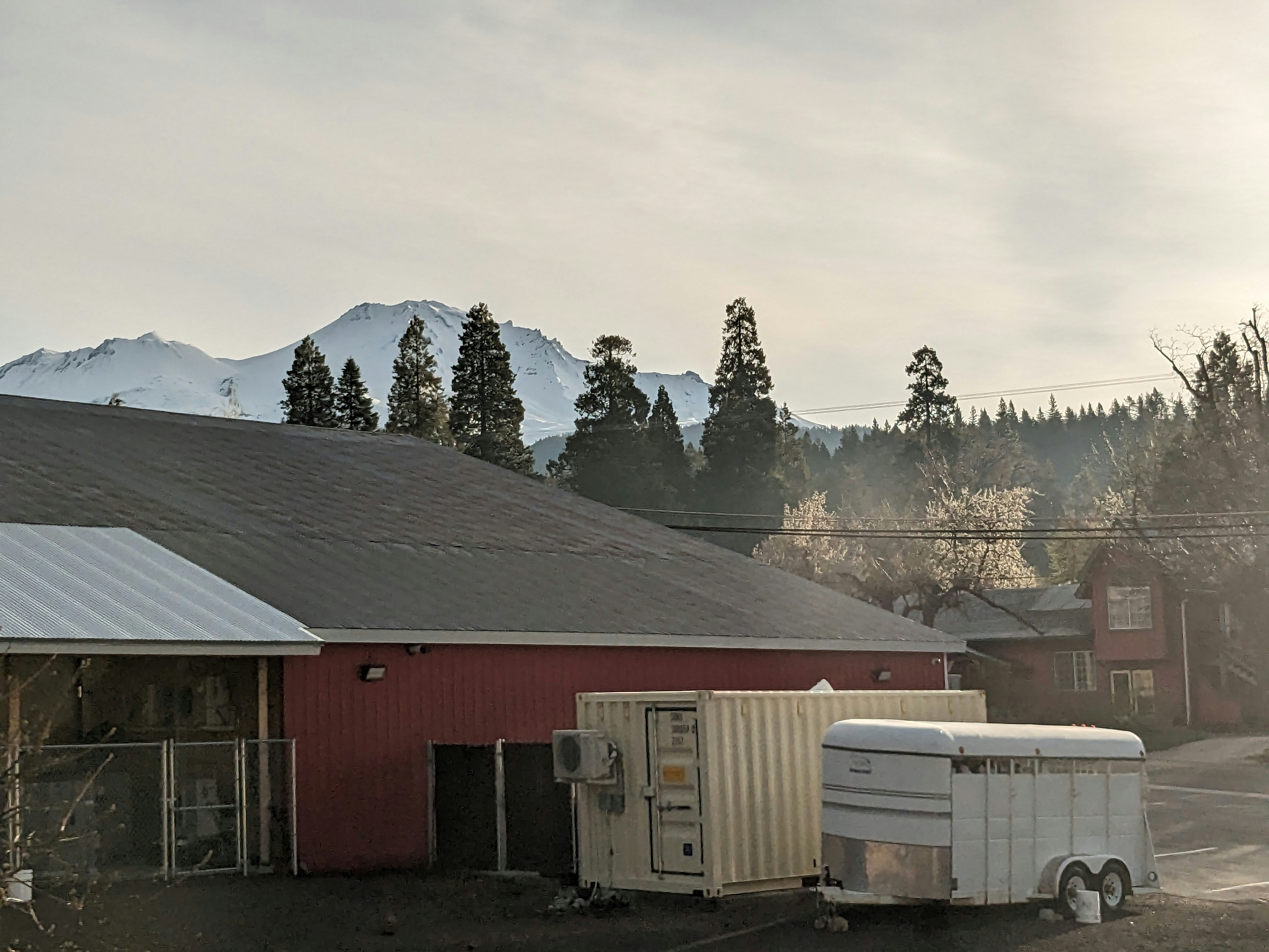 a red barn with a white trailer parked in front of it