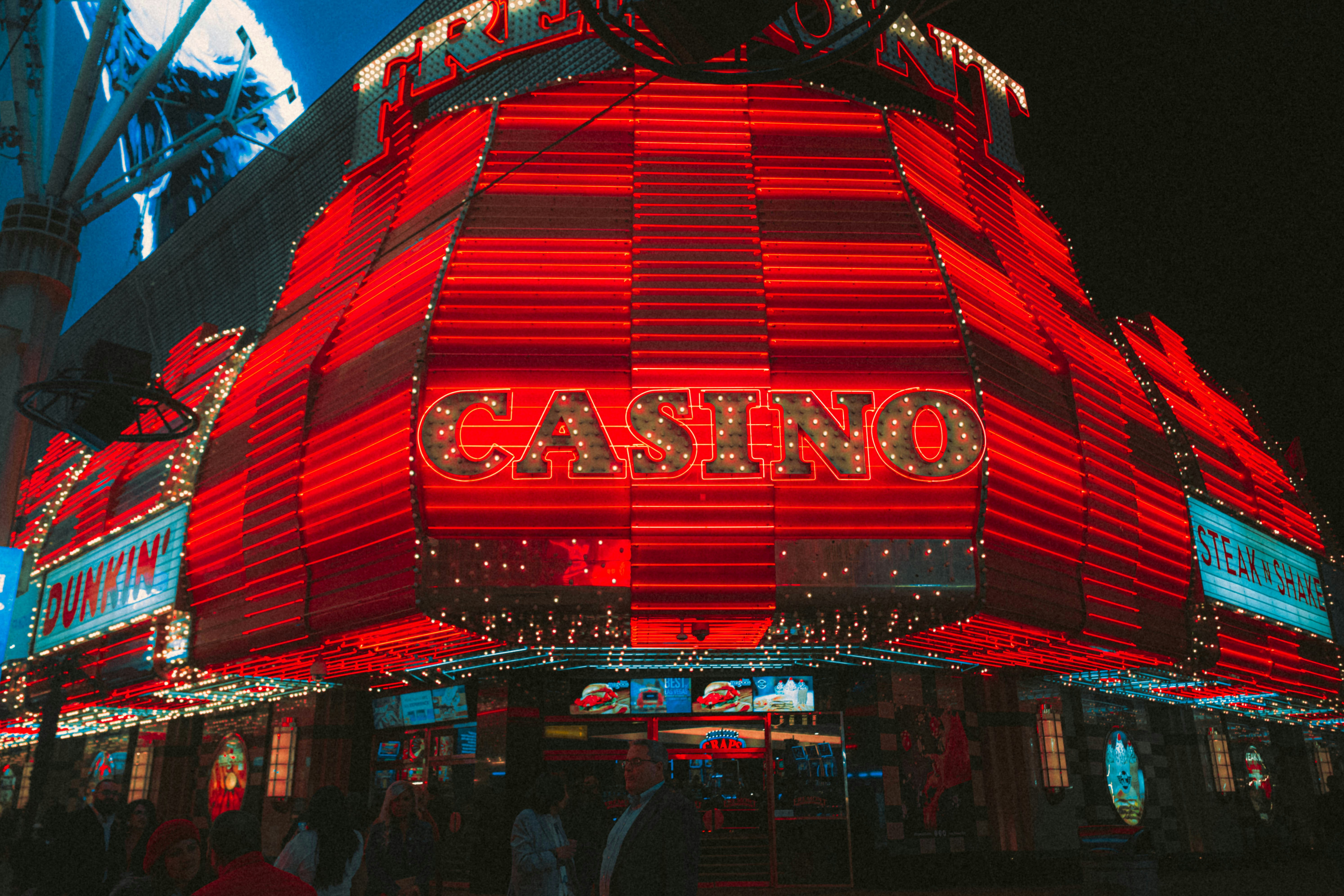 a casino sign lit up at night in front of a building
