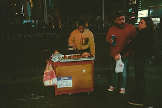 A street vendor preparing hot dogs on a grill with a rustic urban background.