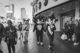 A group of friends wearing Sharp Denji outfits, laughing and walking down a city street.