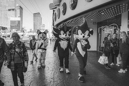 A group of friends wearing Sharp Denji outfits, laughing and walking down a city street.