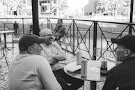 A group of men in casual outfits enjoying a city café.
