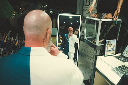 Close-up of a man applying a natural-looking hair patch in front of a mirror