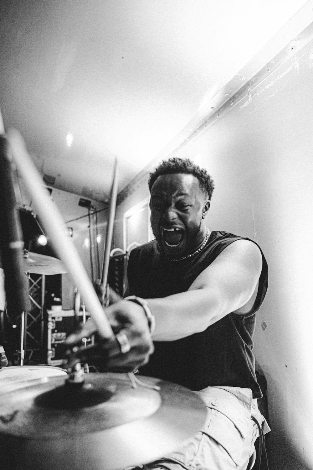 a black and white photo of a man playing drums