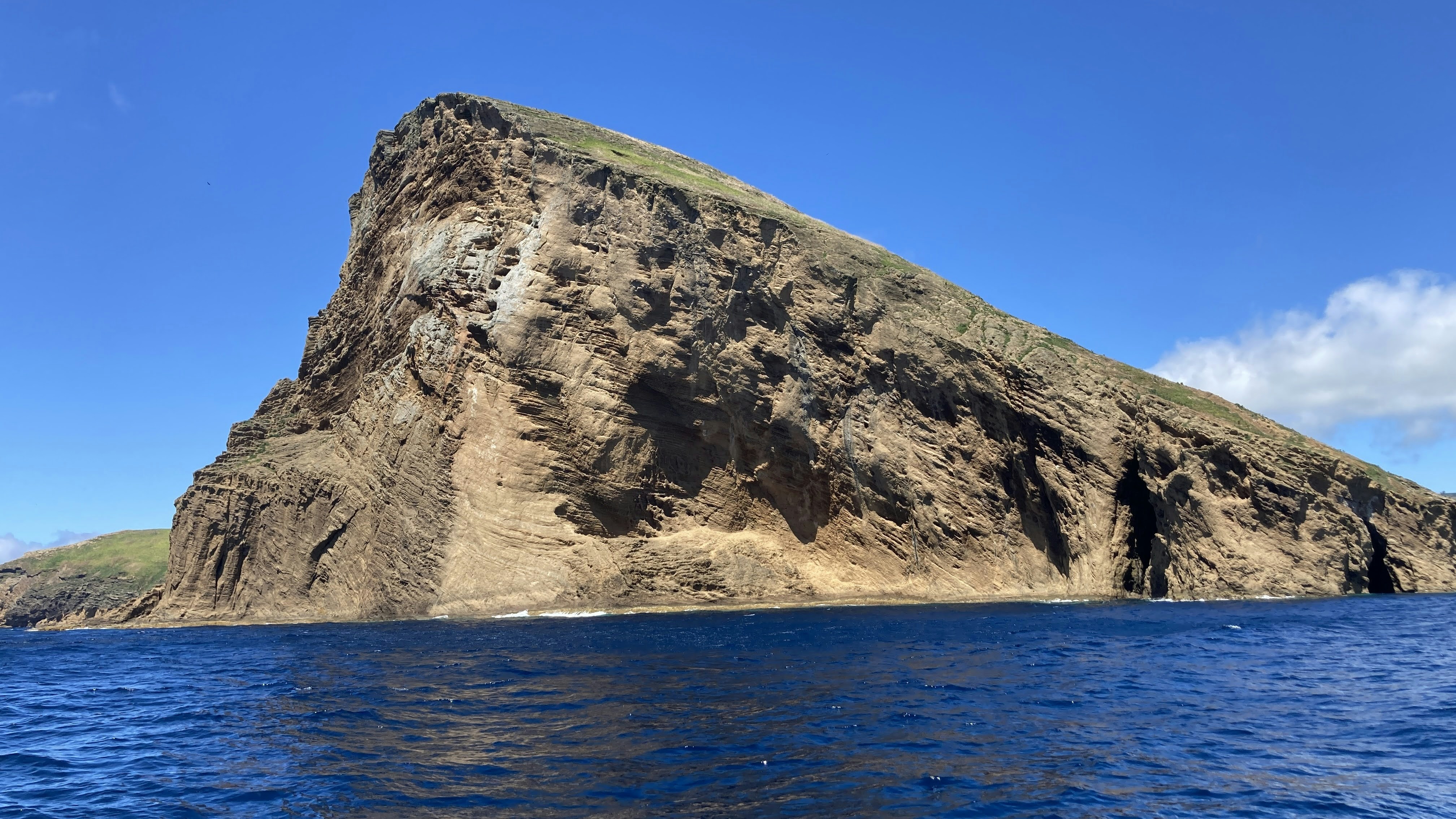 eine große Felsformation in der Mitte eines Gewässers