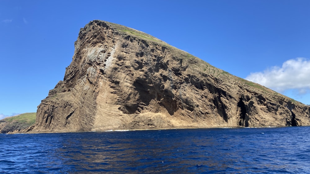 a large rock formation in the middle of a body of water