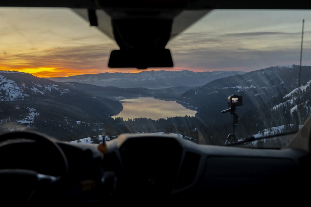 a view from inside a vehicle of a lake and mountains