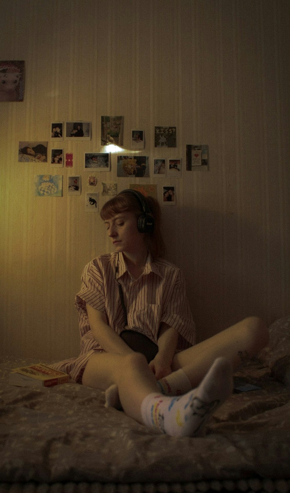 uma mulher sentada em uma cama usando fones de ouvido