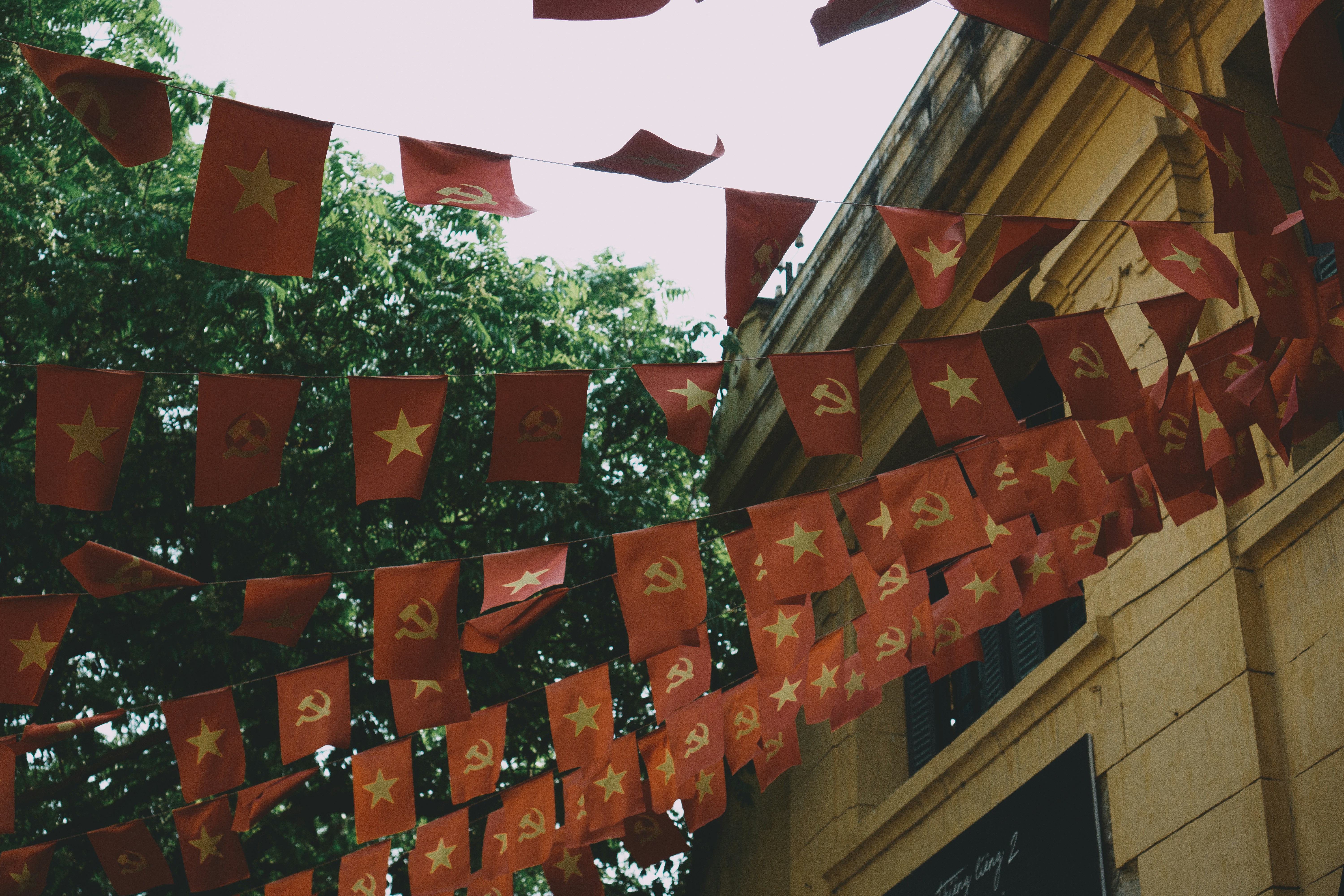 a group of red flags hanging from a building