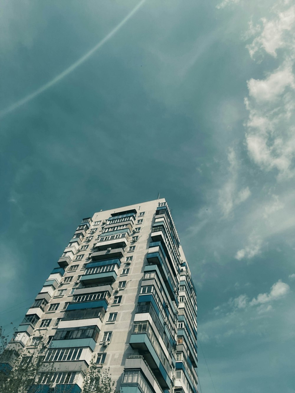 a tall building with lots of windows under a cloudy sky