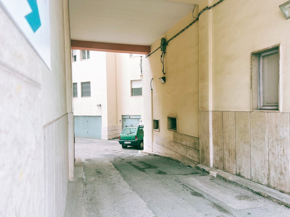 a car is parked in an alley between two buildings