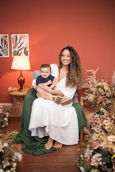 a woman sitting on a chair holding a baby