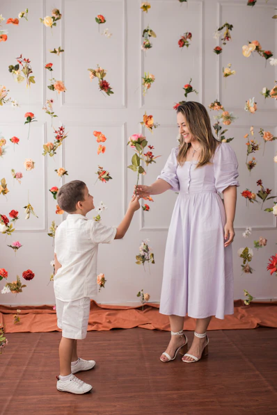 a little boy giving a flower to a woman