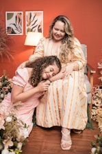 A warm photo of a mother and daughter team planning a wedding together in a cozy studio.