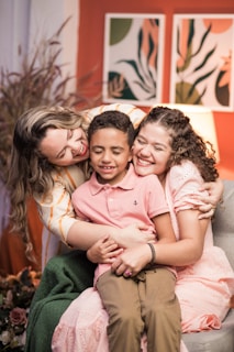 a woman sitting on a couch with two children