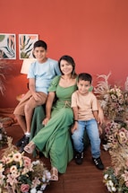 a family posing for a picture in front of a red wall