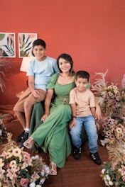 a family posing for a picture in front of a red wall