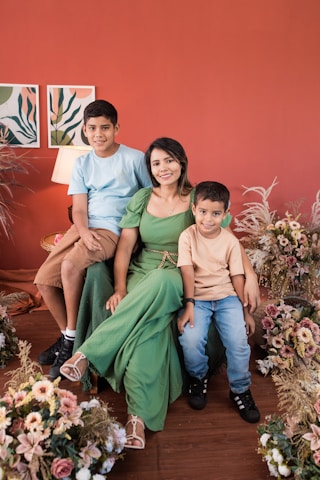 a family posing for a picture in front of a red wall