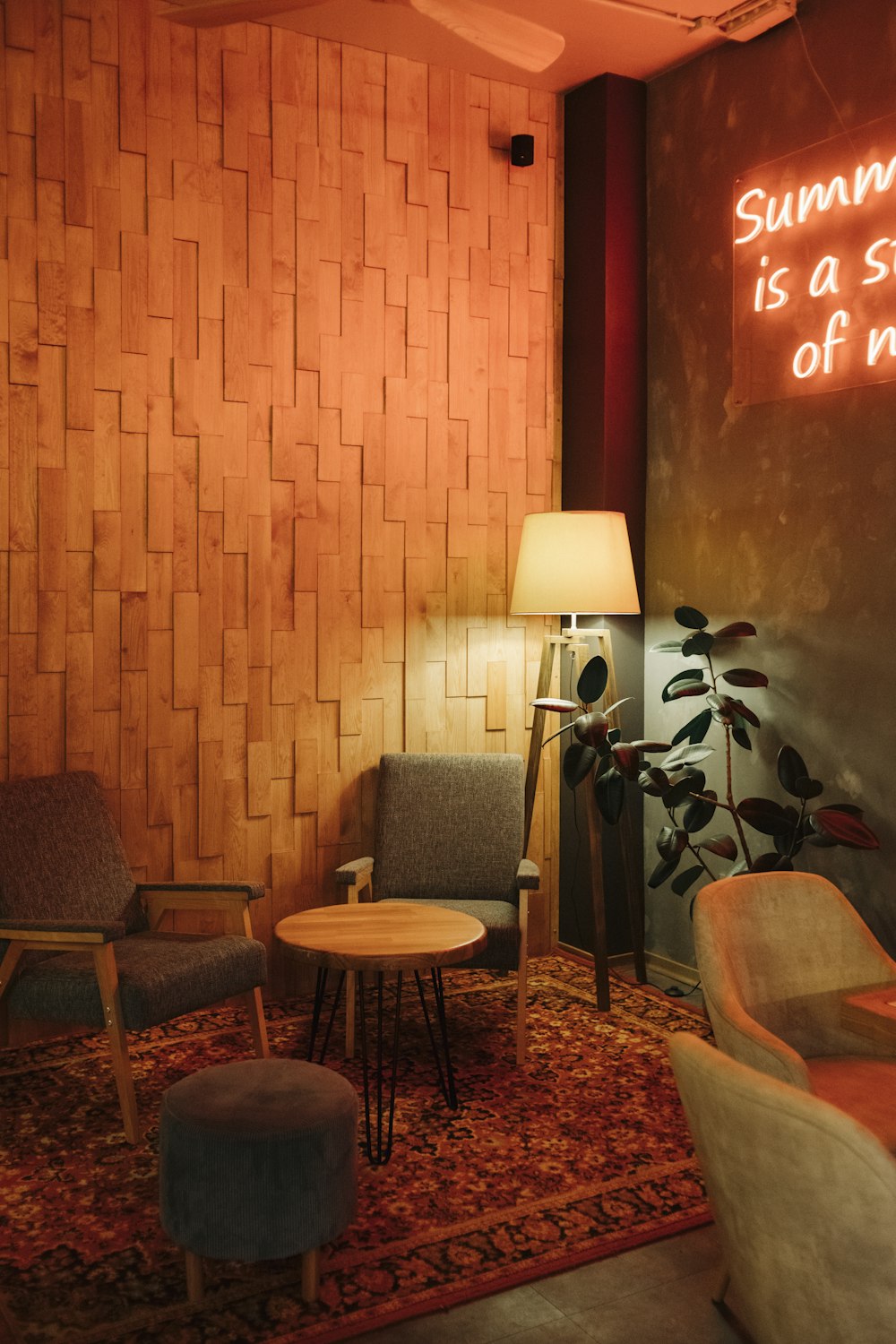 a living room filled with furniture and a neon sign