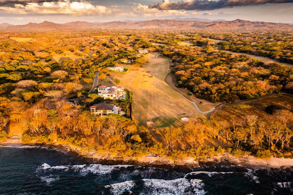 an aerial view of a home on the shore of the ocean