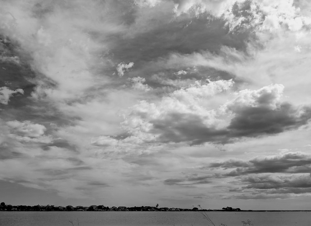 Une photo en noir et blanc de nuages au-dessus d’un plan d’eau