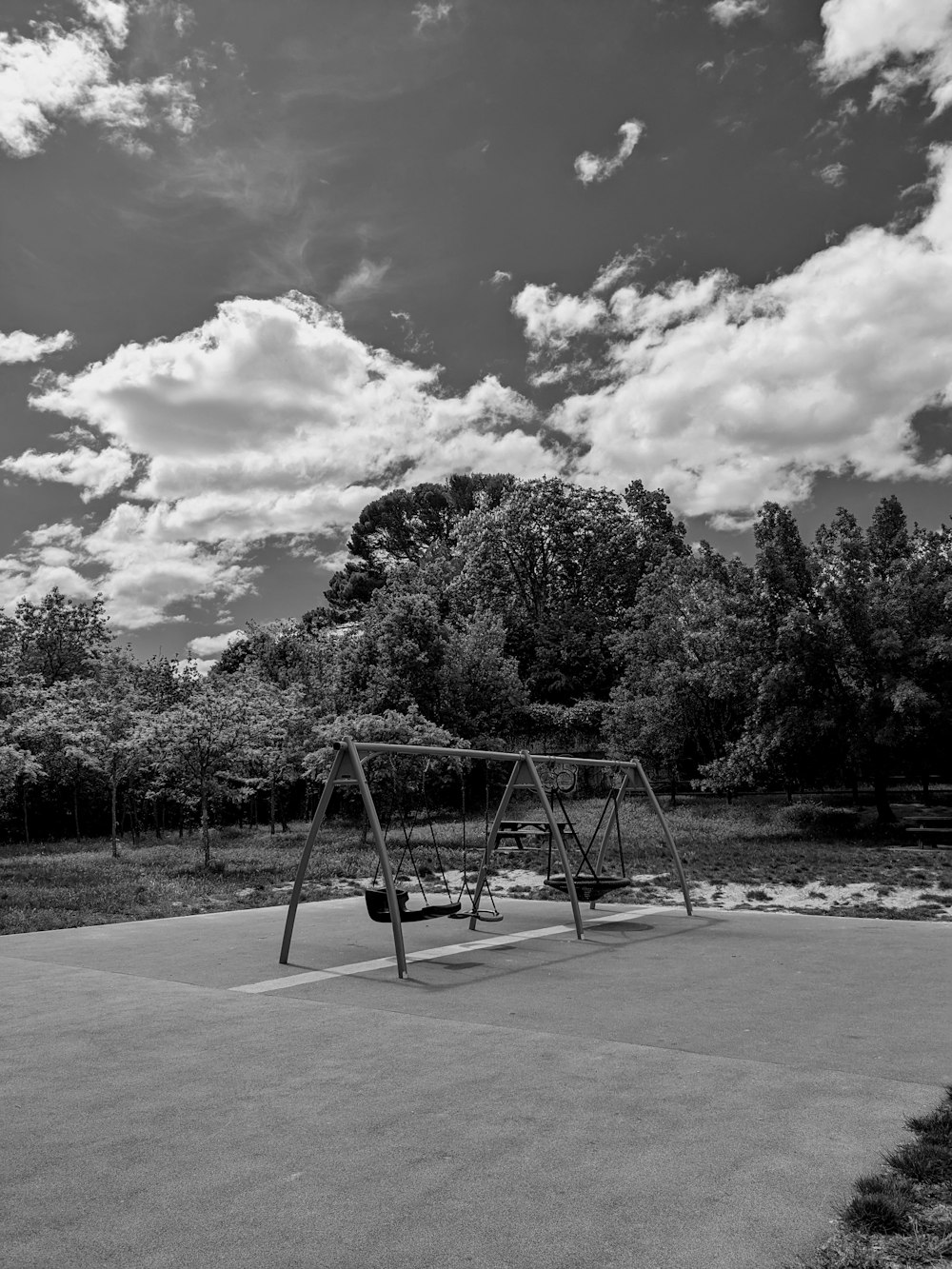 a black and white photo of a swing set