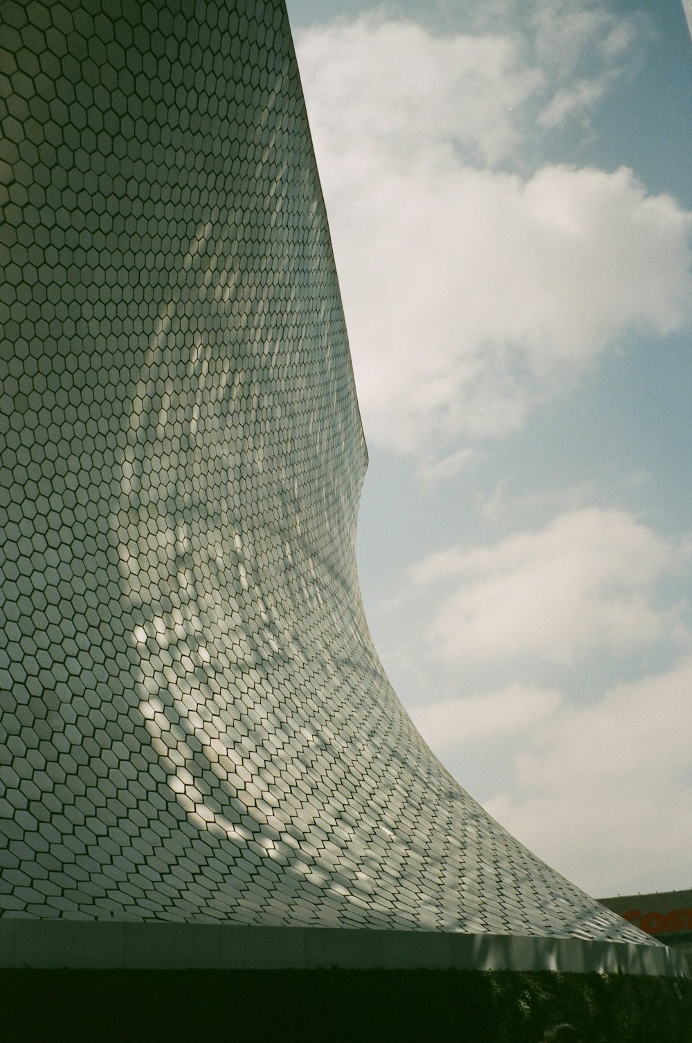 a building with a curved roof and a sky background