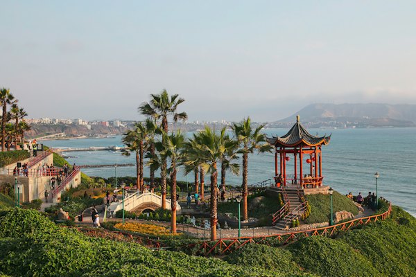 A view of the ocean with palm trees and a pagoda in the foreground — Lima, Peru