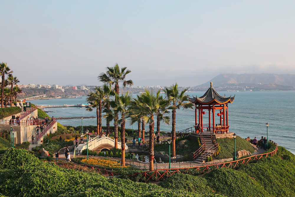 a view of the ocean with palm trees and a pagoda in the foreground