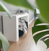 Close-up of a sleek marble and steel console table in a bright, minimalist living room.