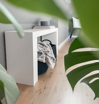 Minimalist wall art in muted gold and olive green tones hanging above a charcoal gray console table.