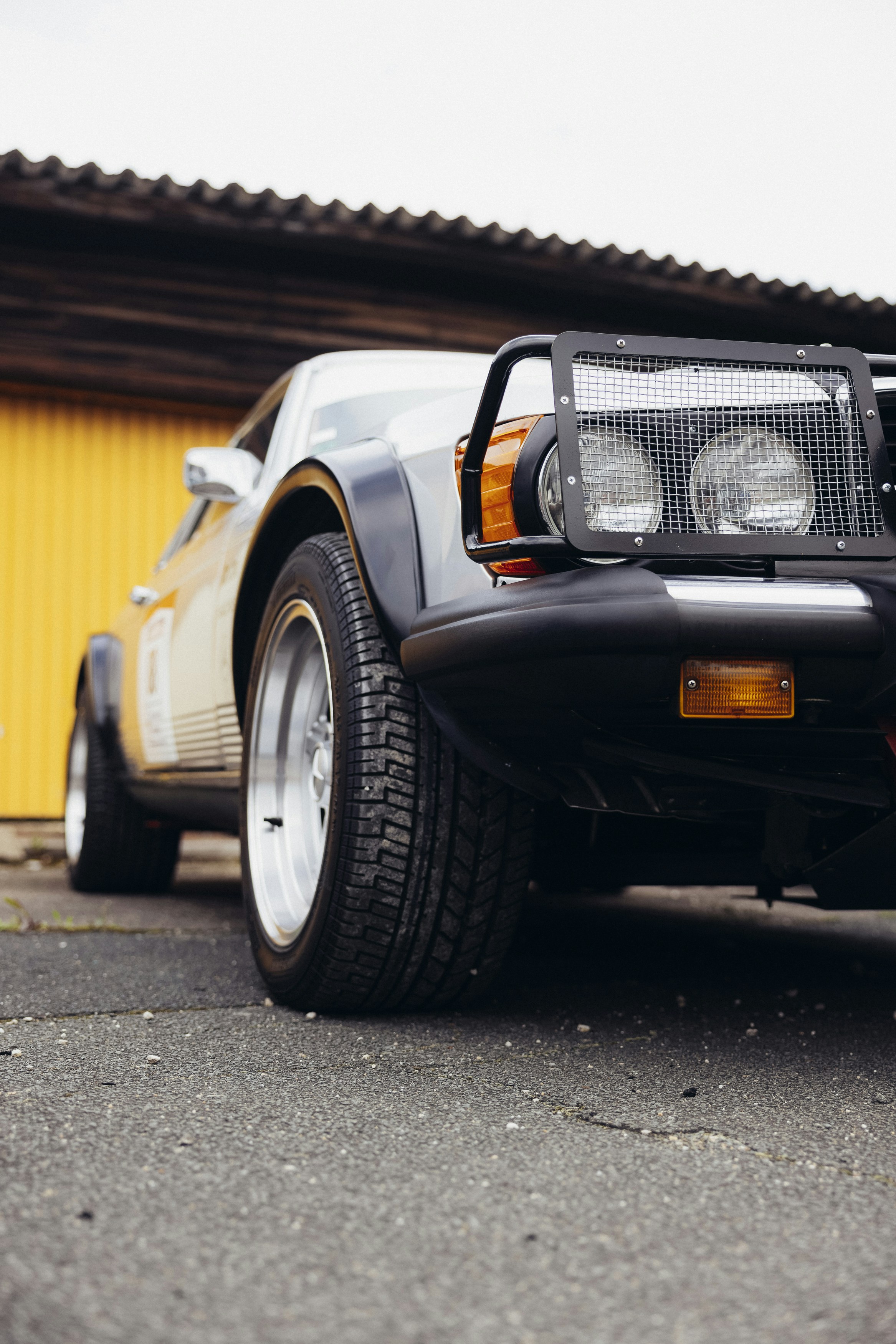 a black sports car parked in front of a yellow building