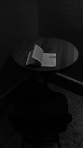 An author signing books at a dimly lit rustic wooden table.